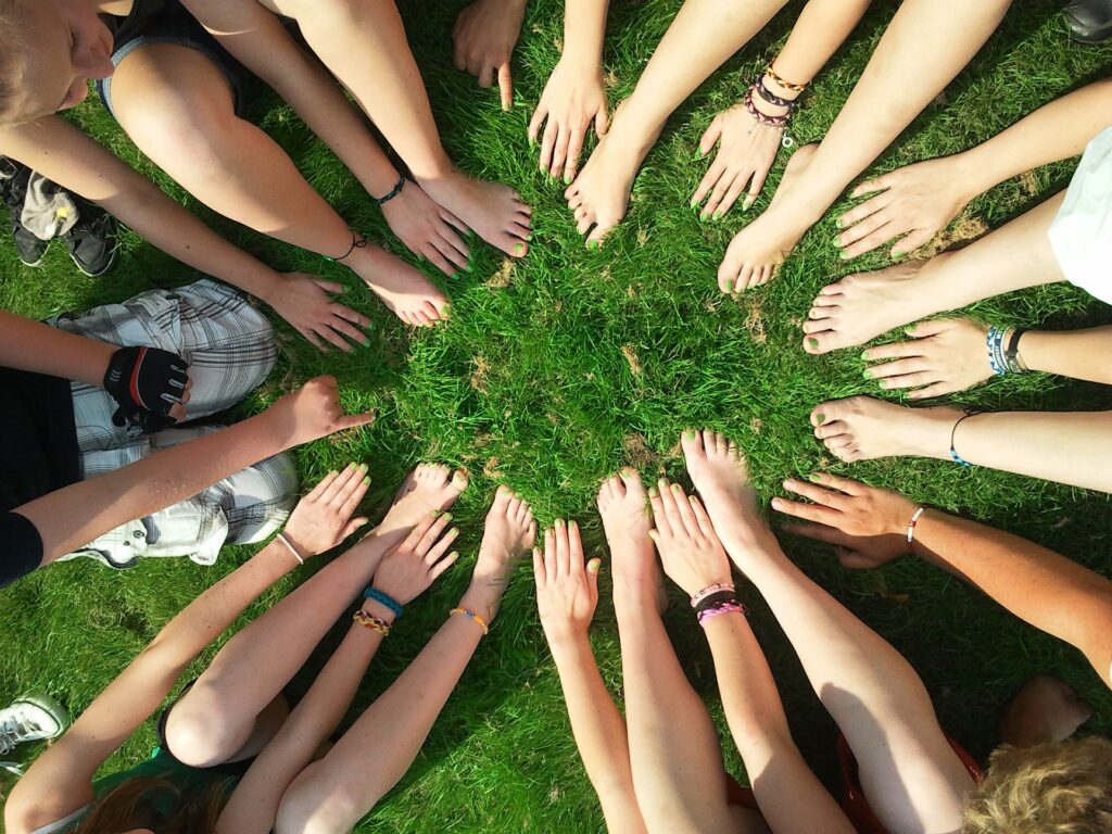 A stock image showing feeds and hands of sevreral people gathered together in a circle
